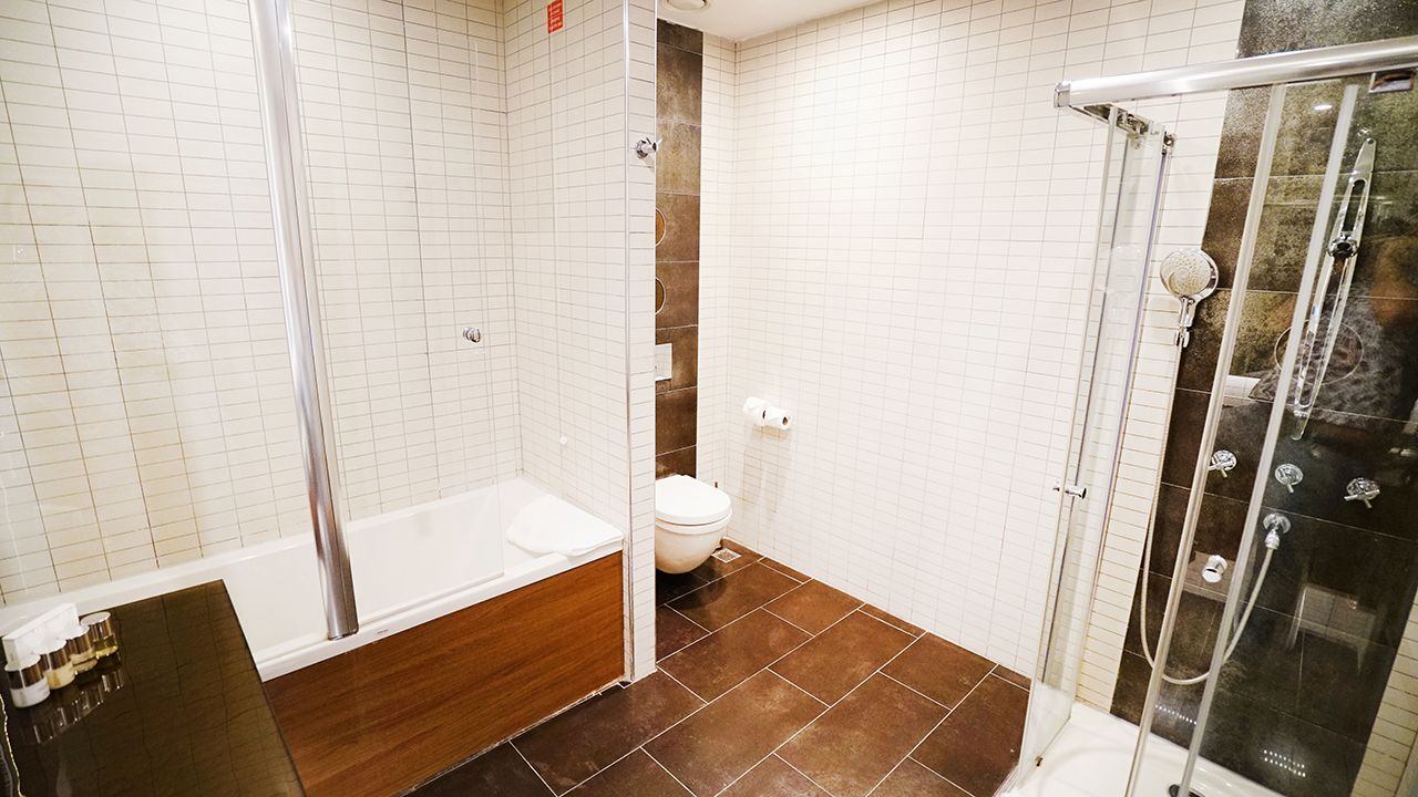 A modern bathroom with a bathtub, shower, and toilet.