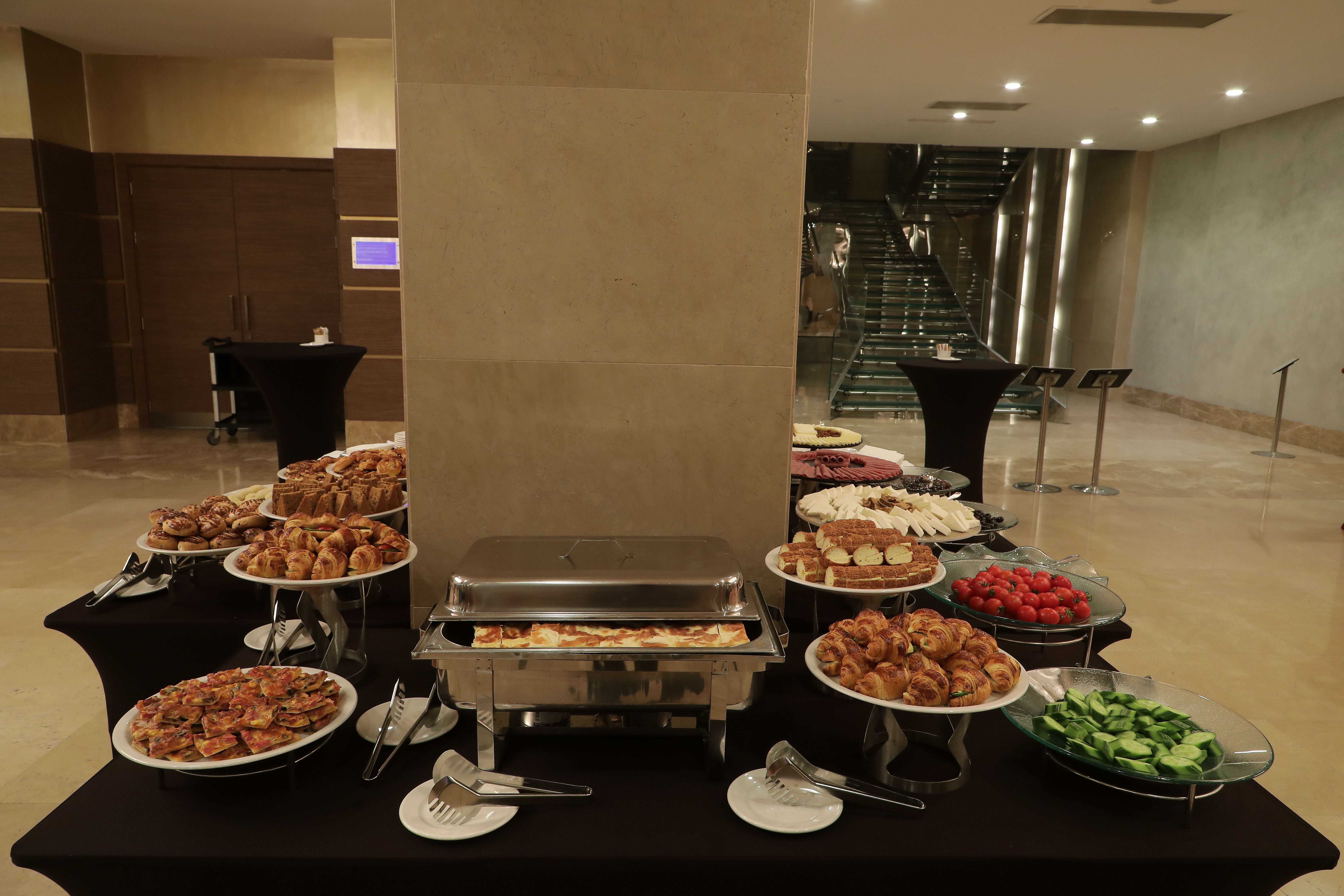 A buffet table with hot dishes and desserts arranged for an event indoors.