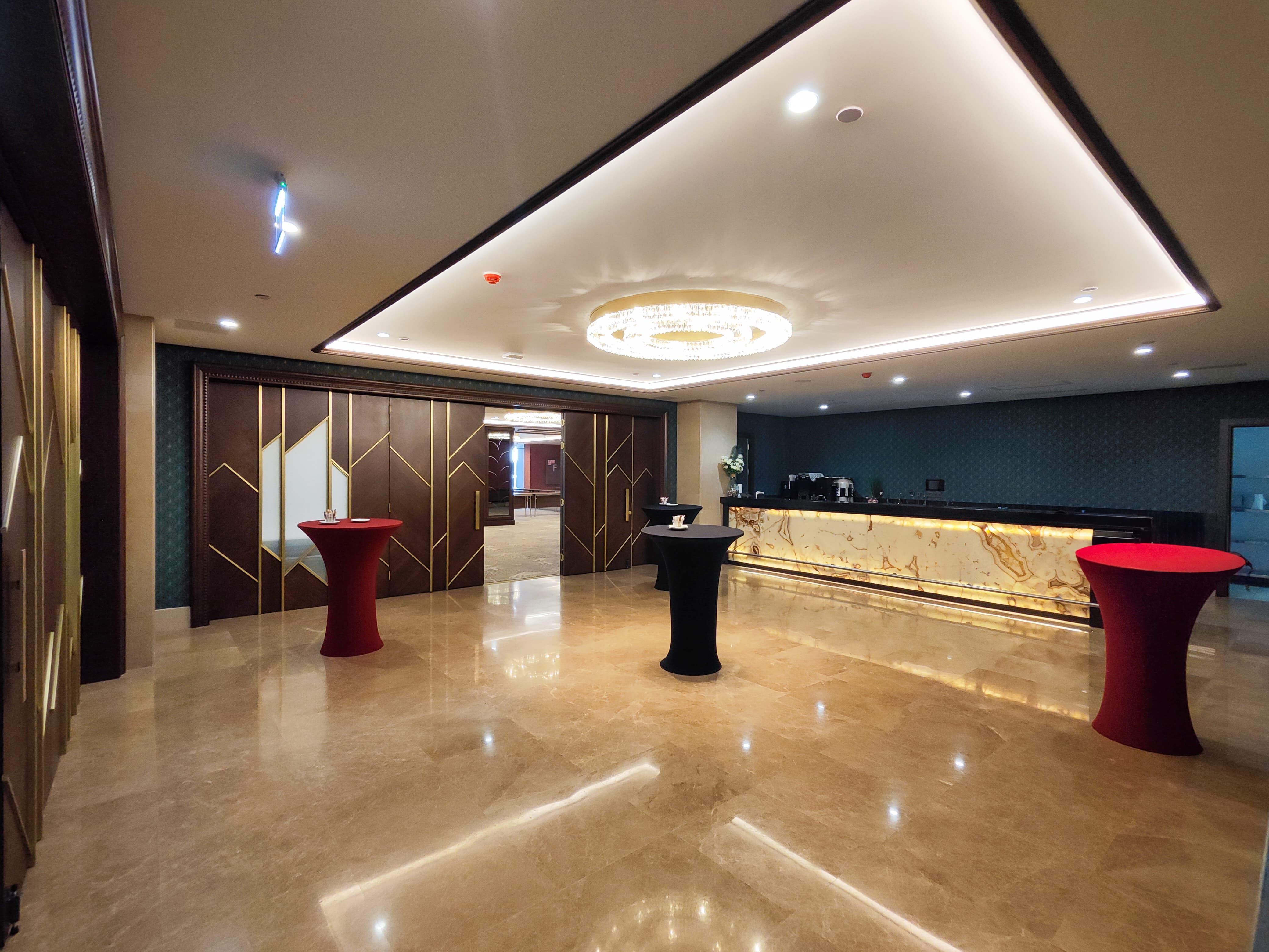 A modern, elegant reception area with marble floors, a reception desk, and cocktail tables.